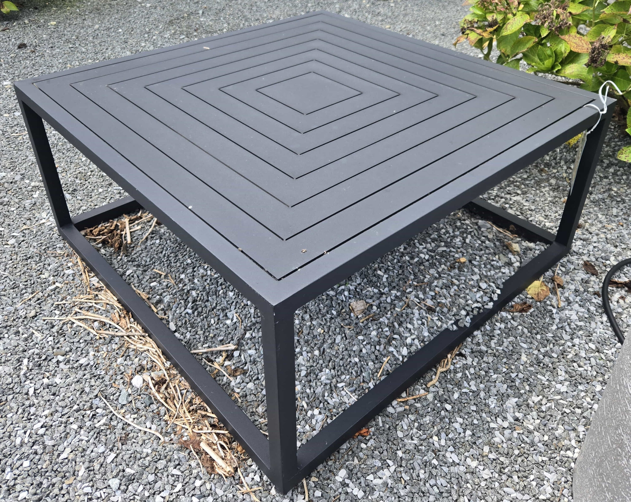 a square table sitting on top of a gravel ground