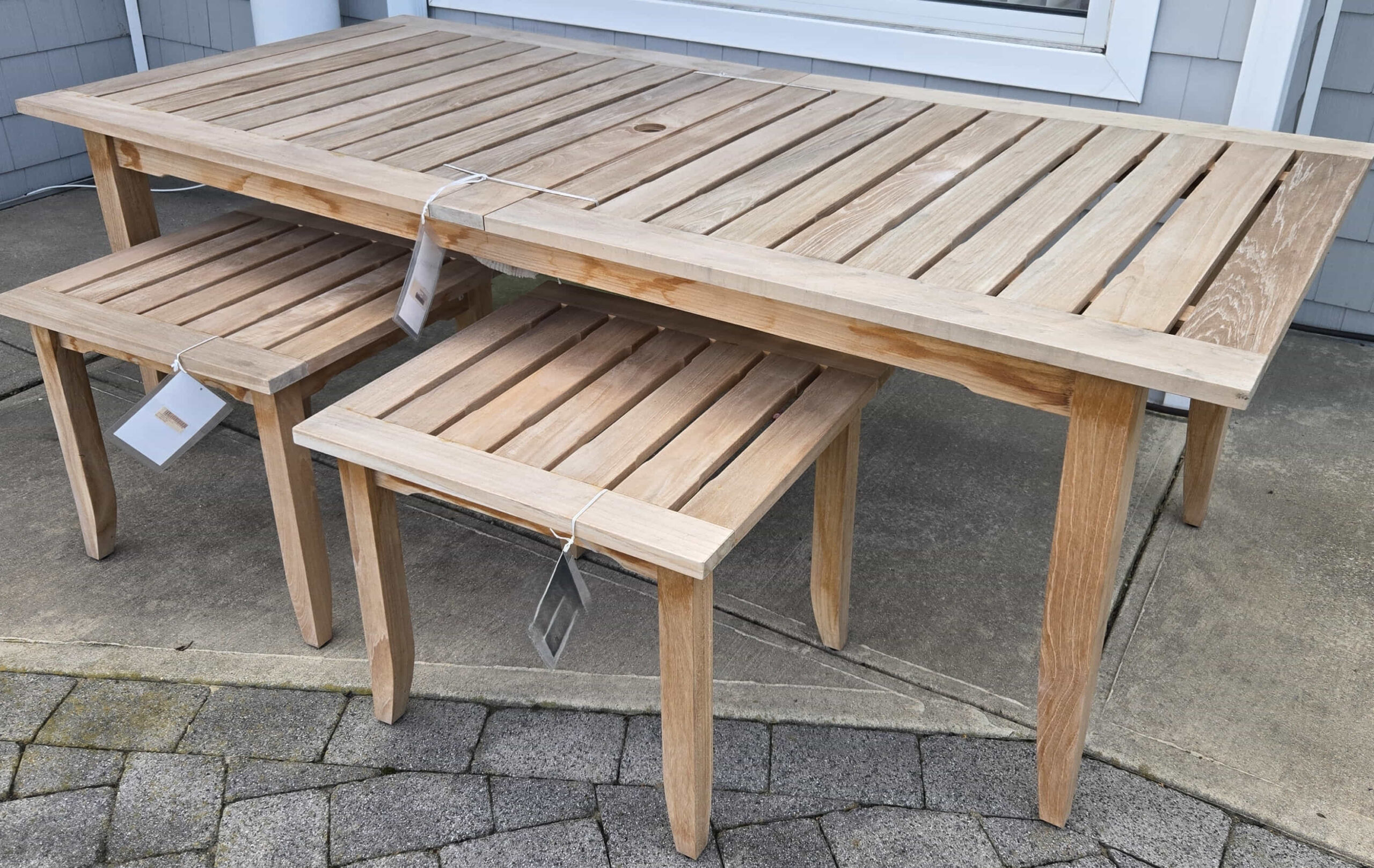 a wooden table and two chairs on a patio