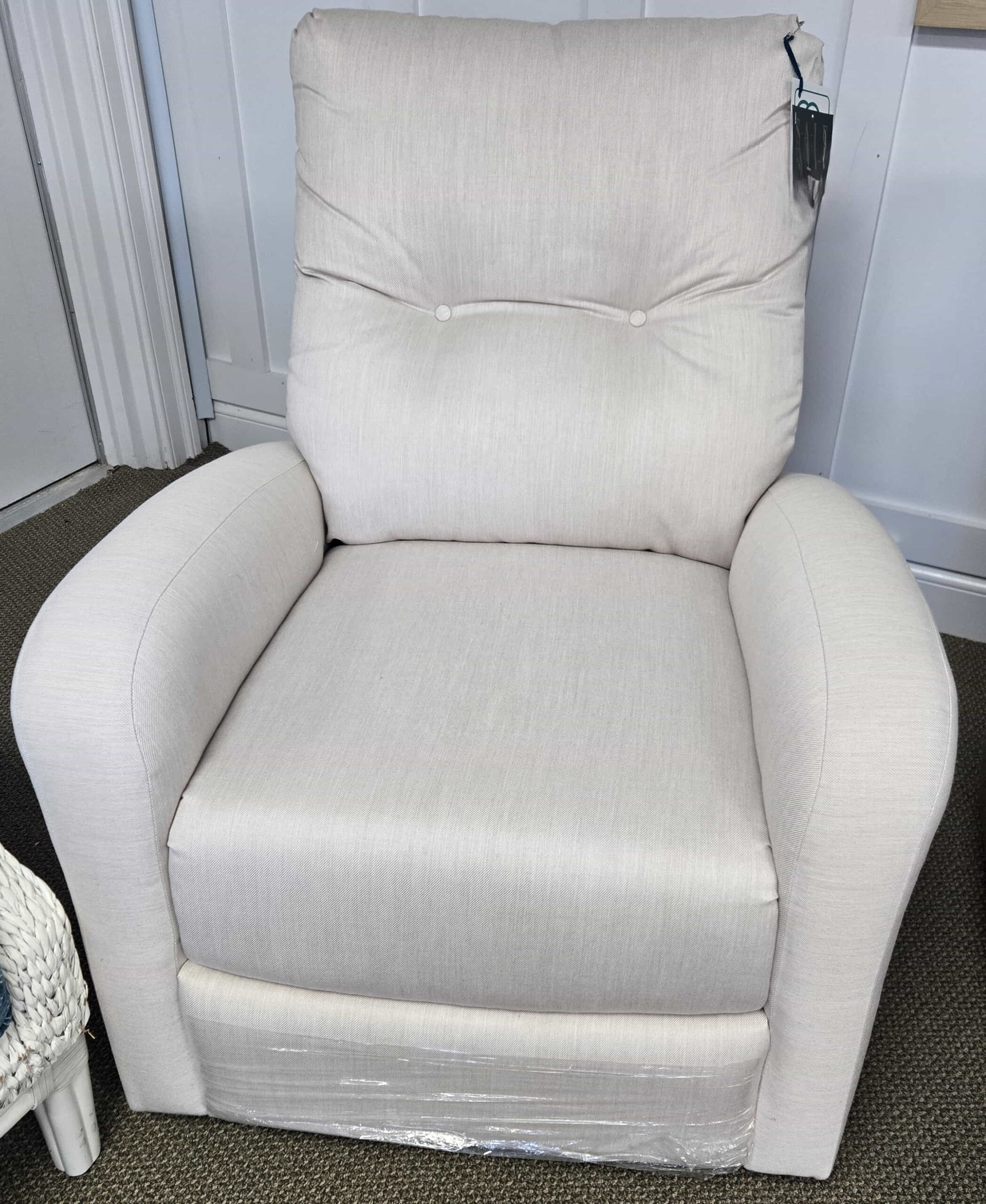 a white chair sitting in a living room next to a lamp