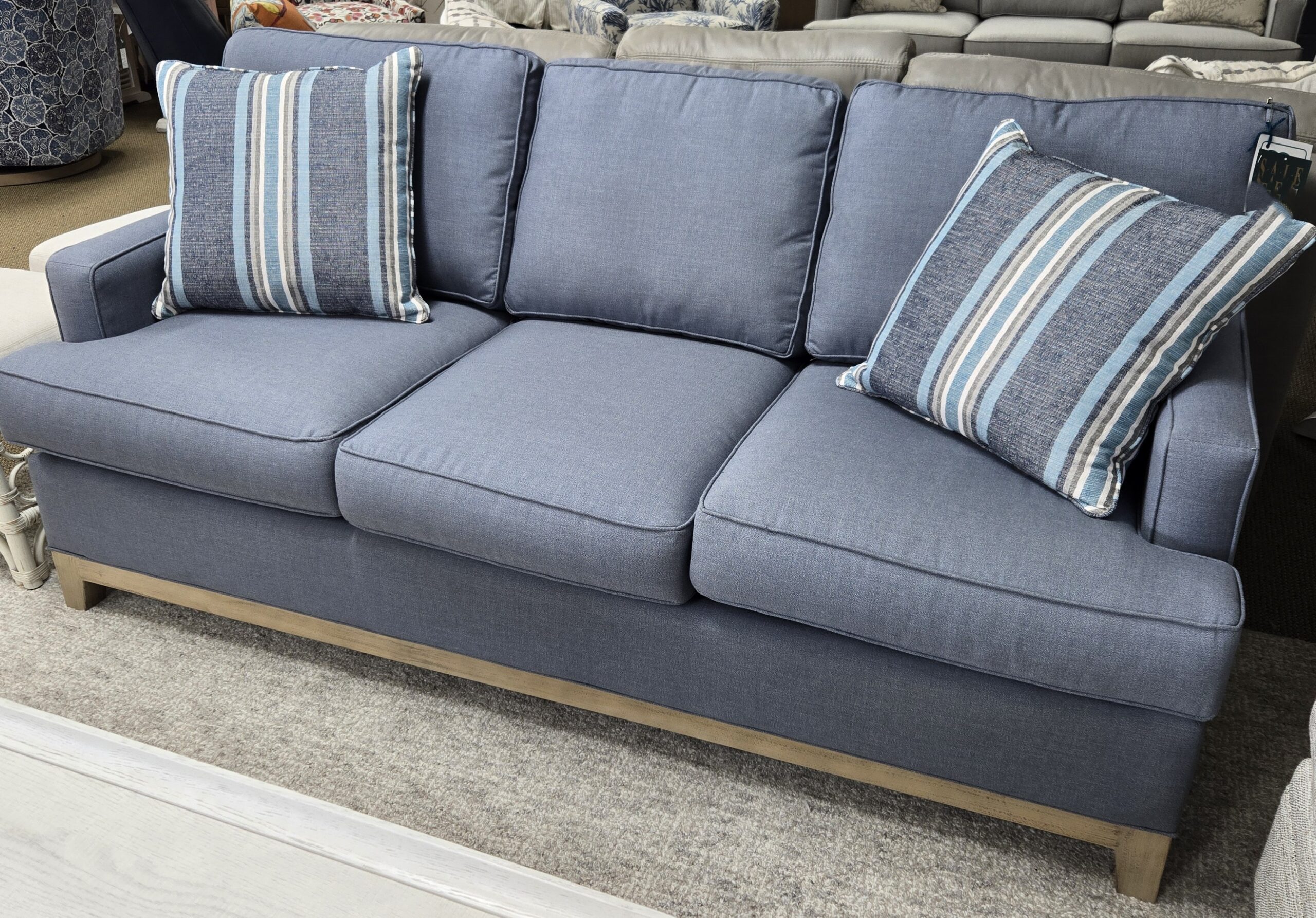 a blue couch sitting on top of a carpet covered floor