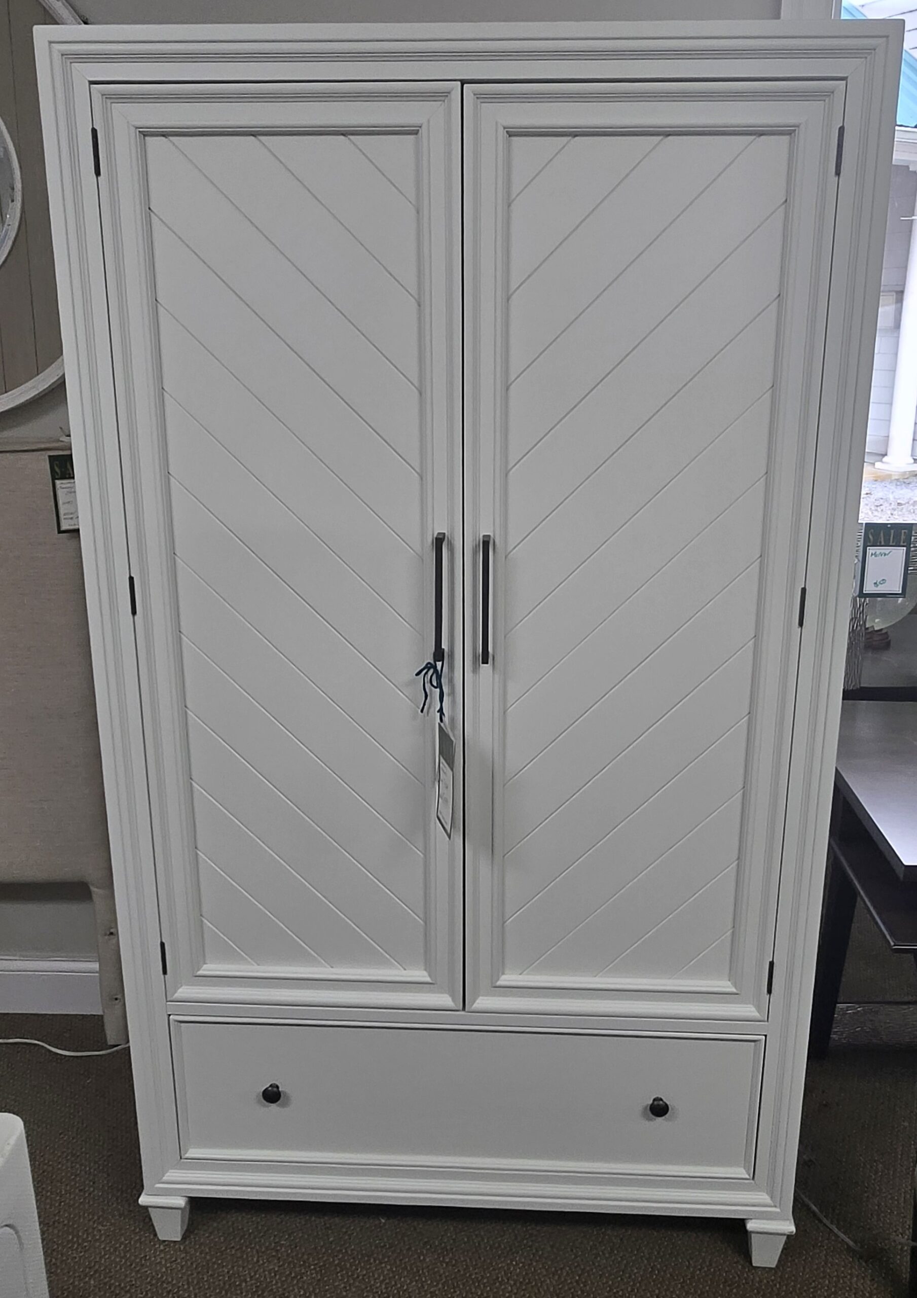 a white armoire in a room next to a window