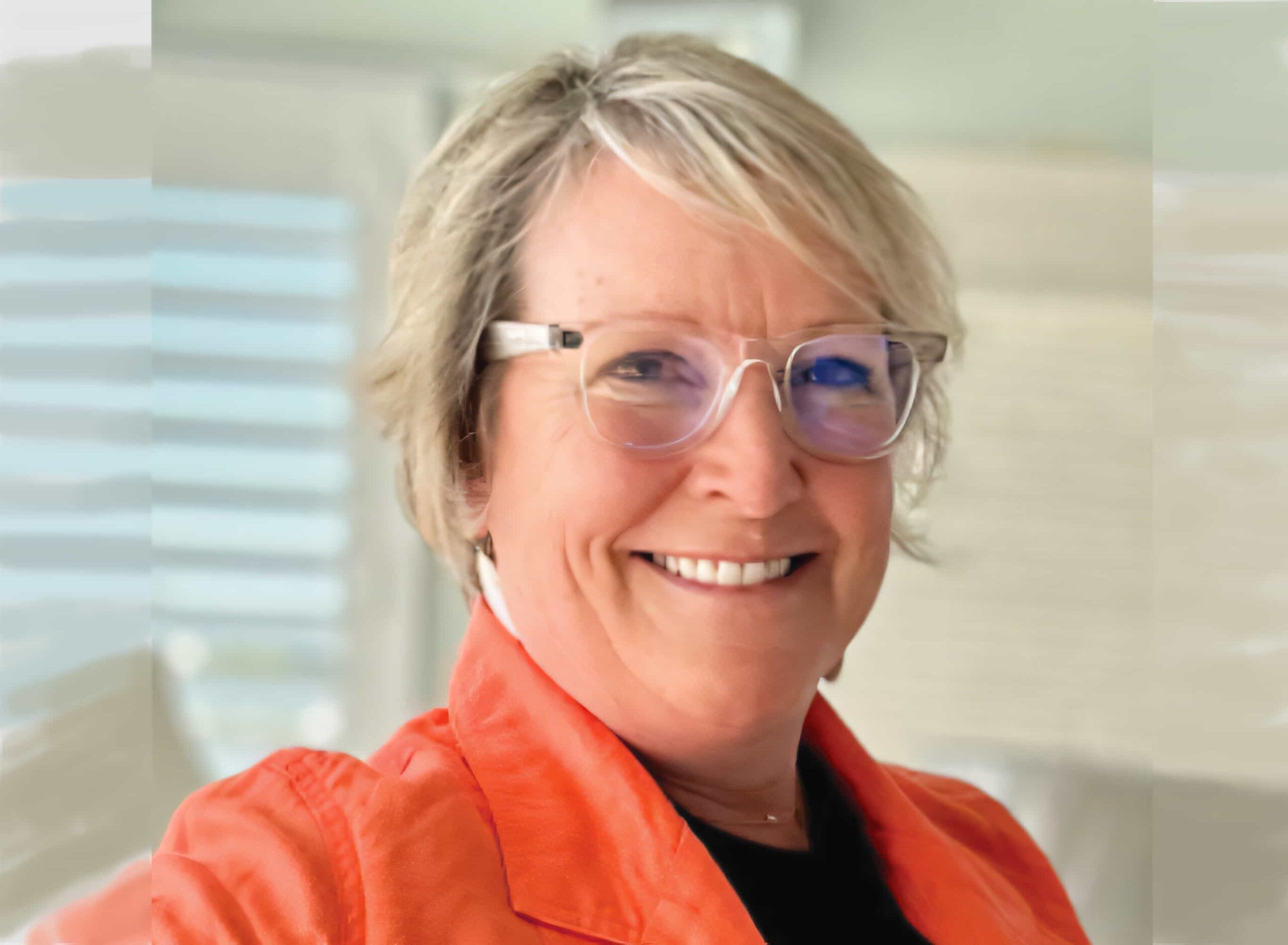 a woman wearing glasses and an orange jacket