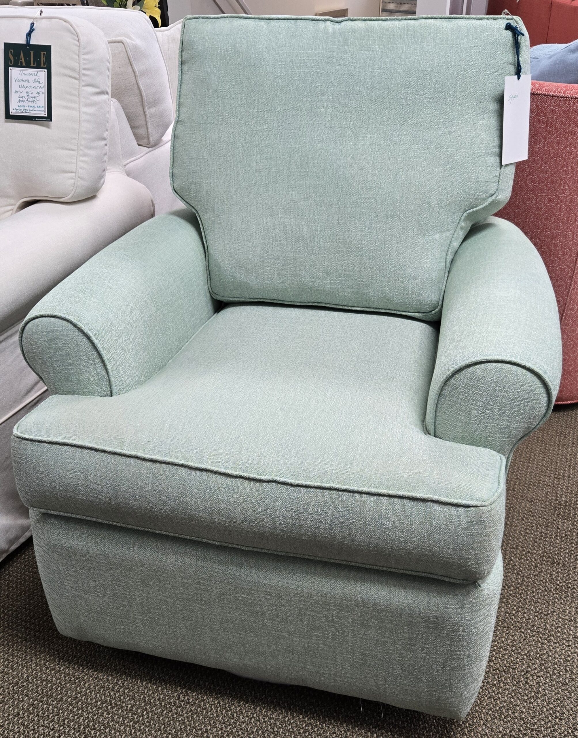 a light blue chair sitting on top of a carpeted floor