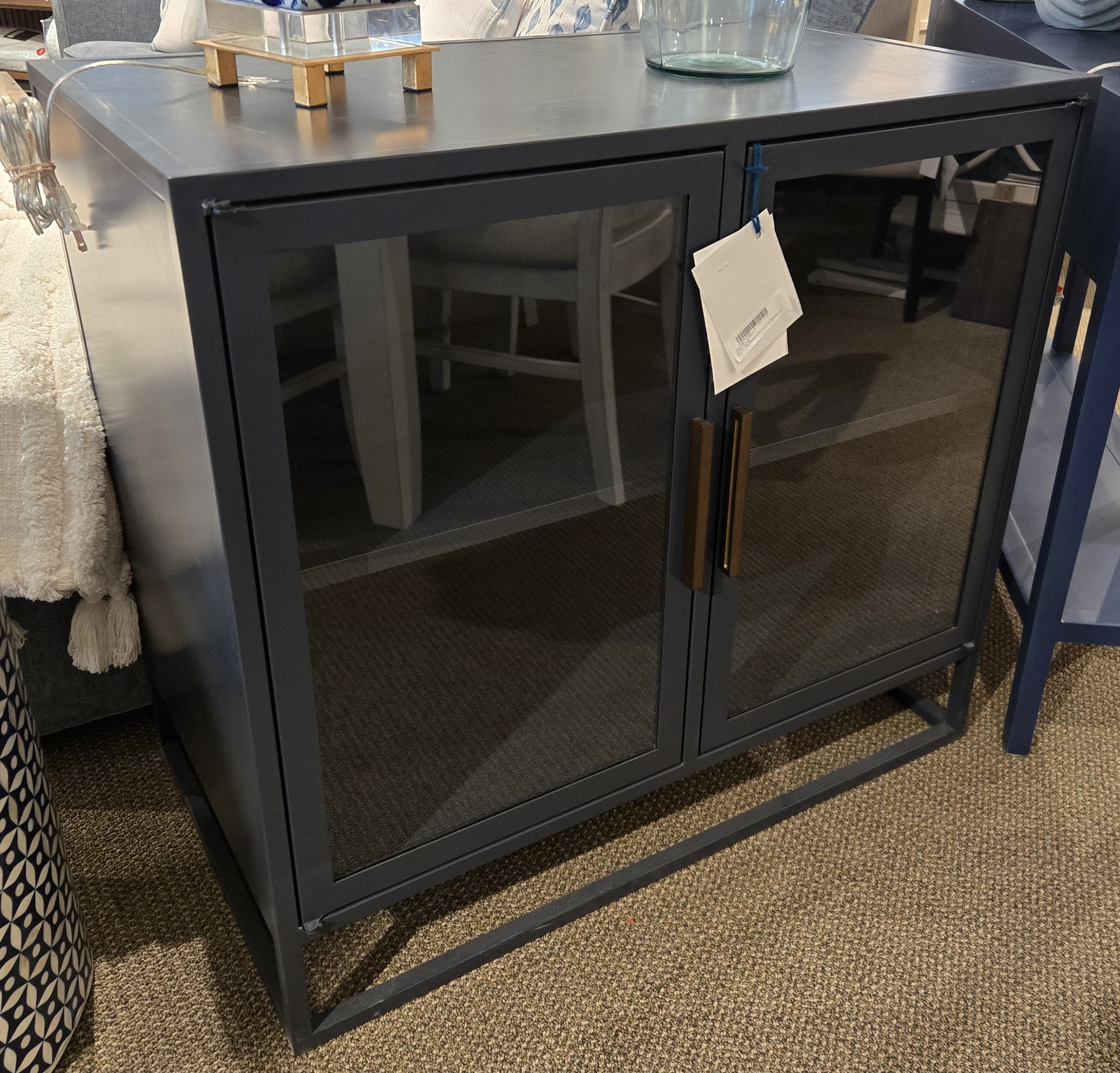 a table with a glass door and a chair next to it