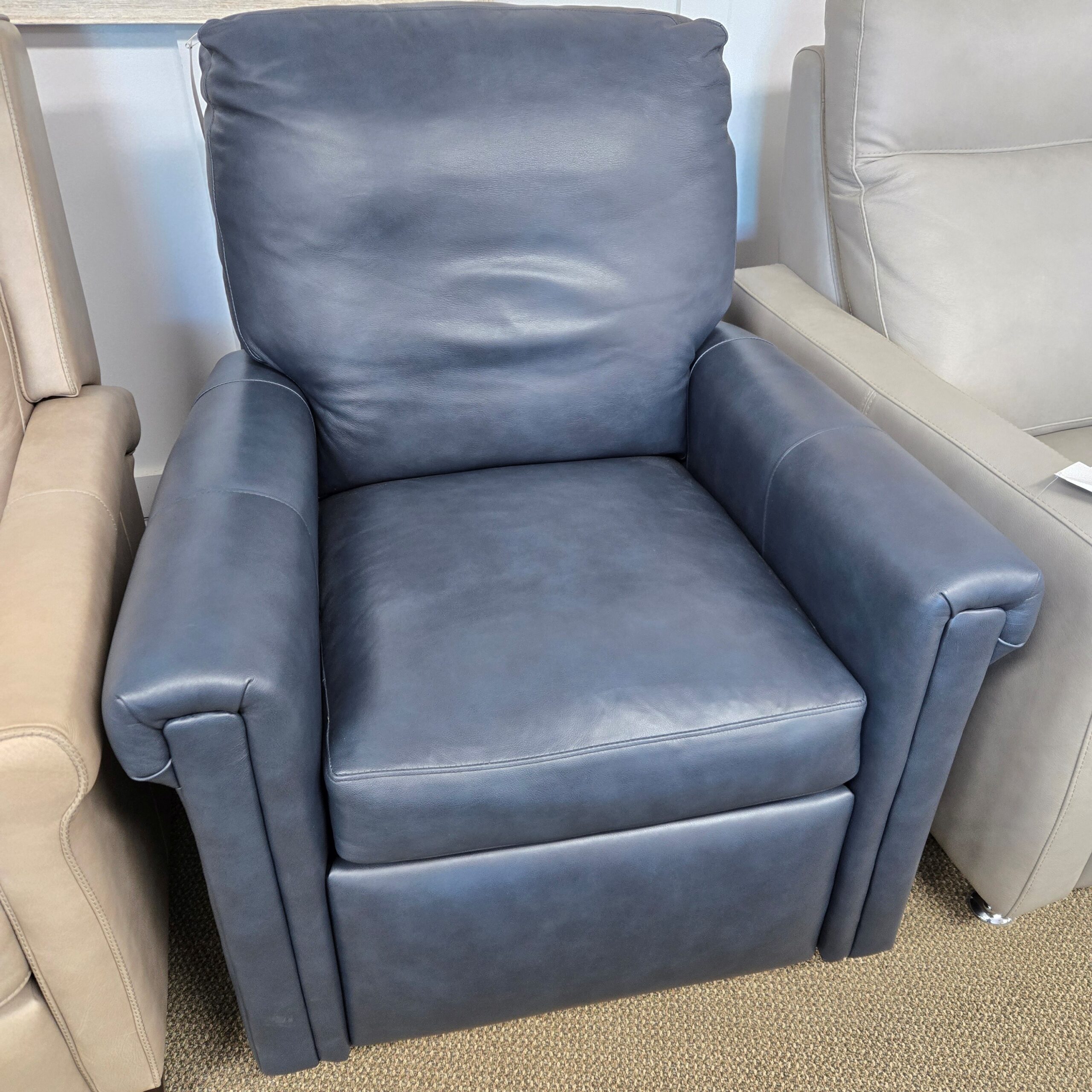 a blue leather recliner sitting on top of a couch