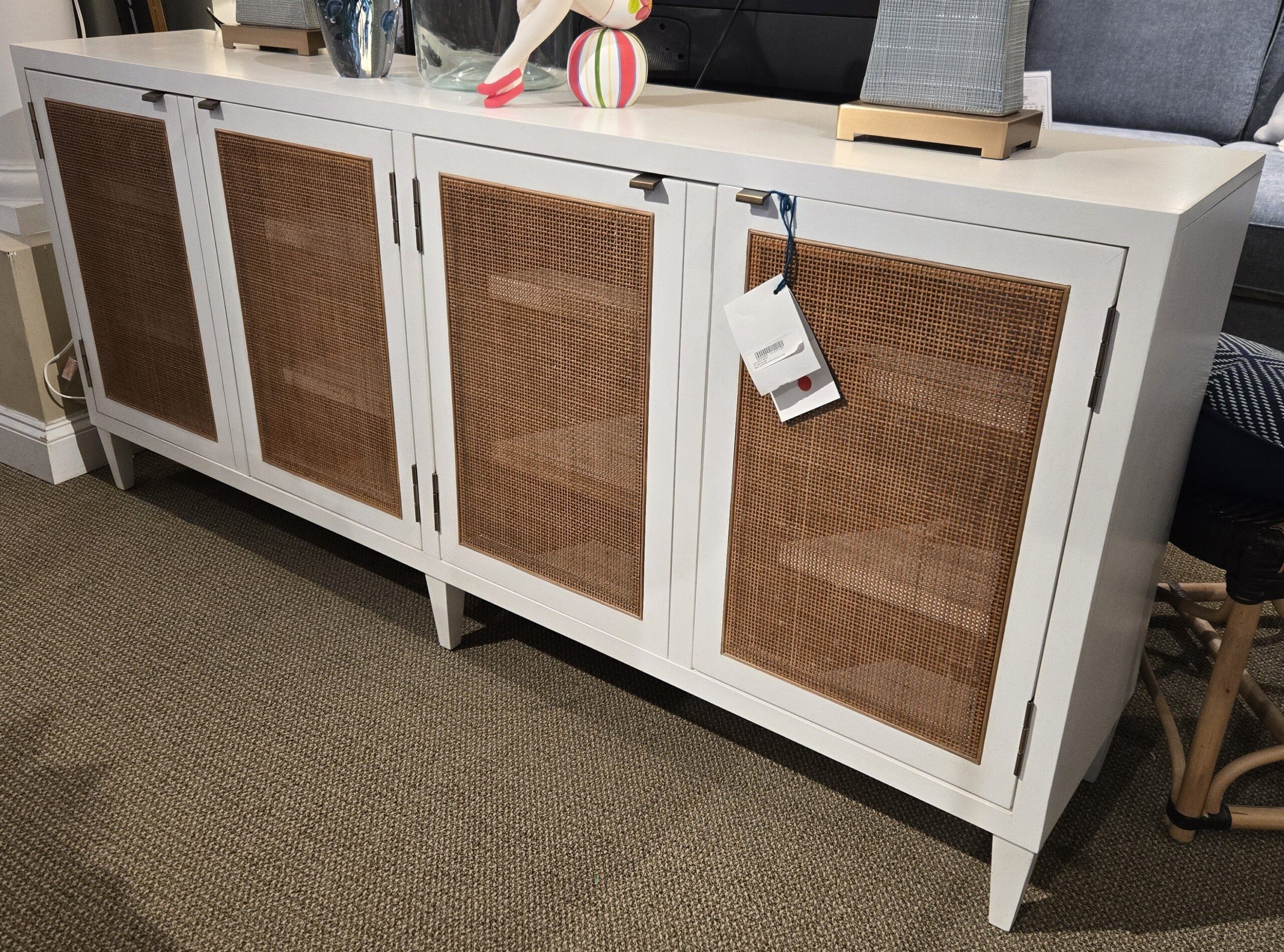 a white sideboard with wicker doors in a living room