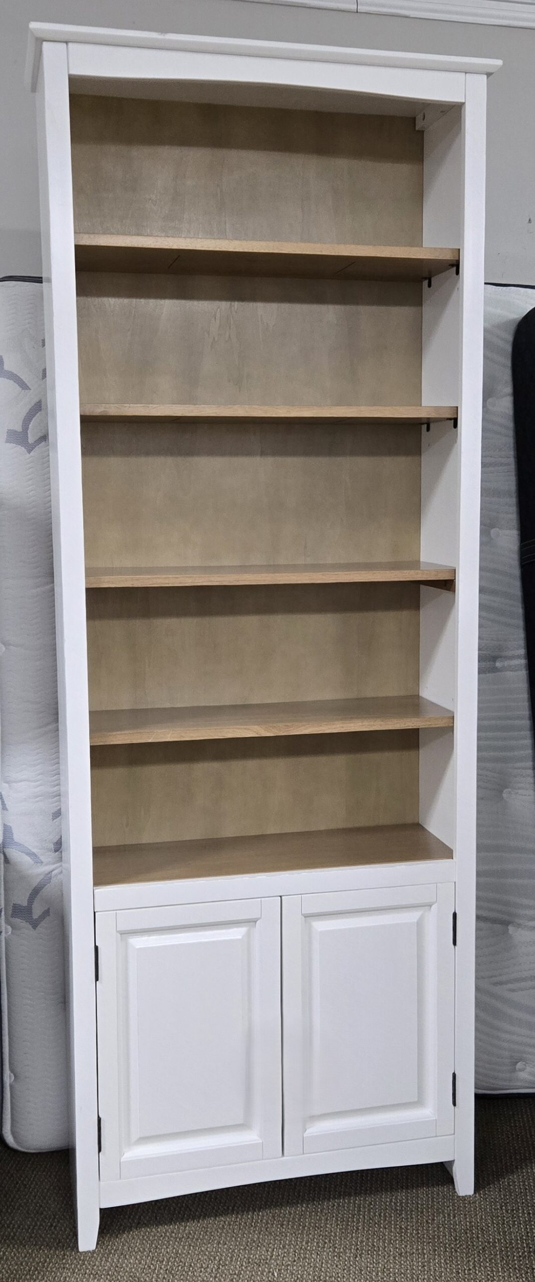 a white bookcase with two doors and two drawers