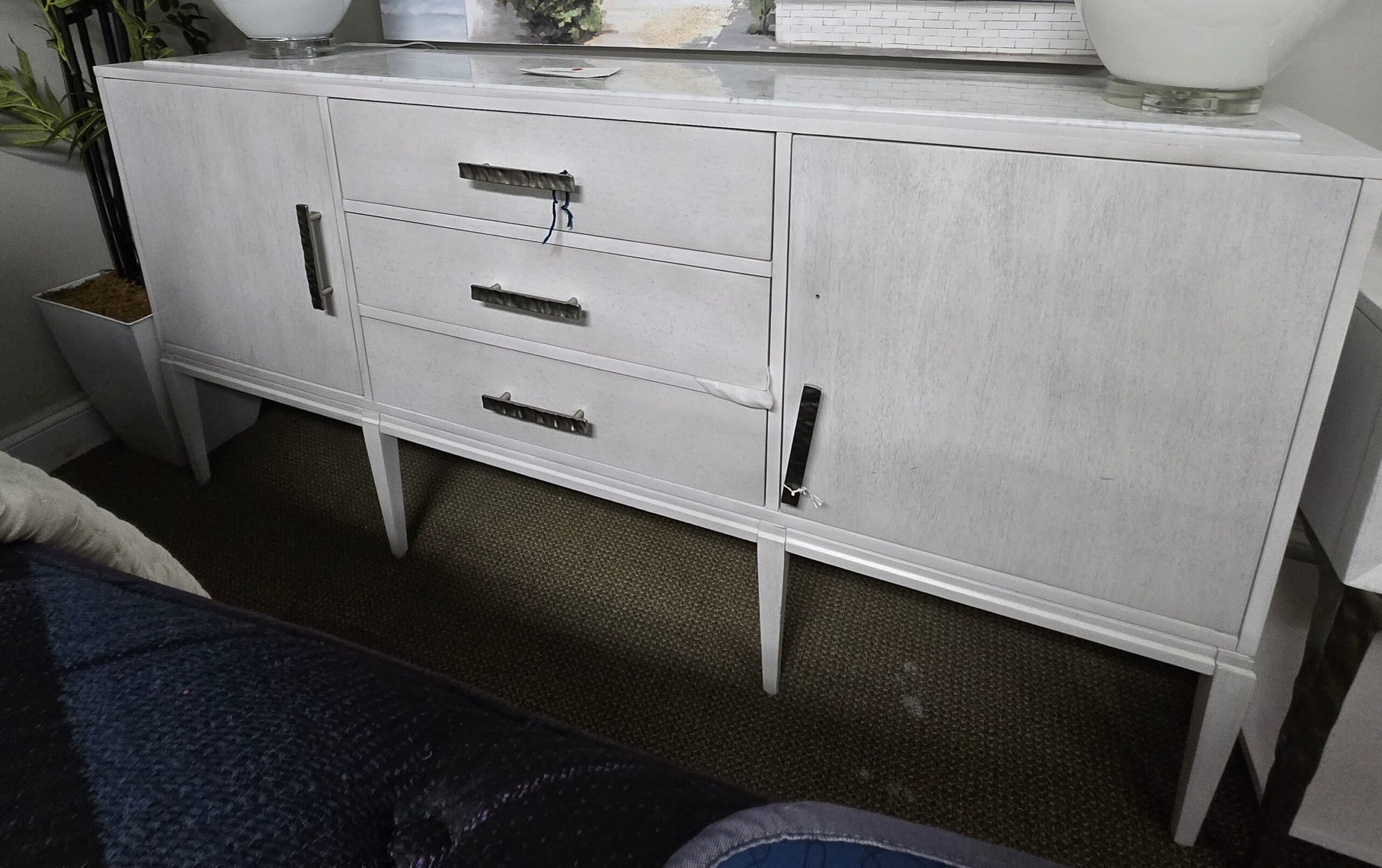 a white dresser with two vases on top of it
