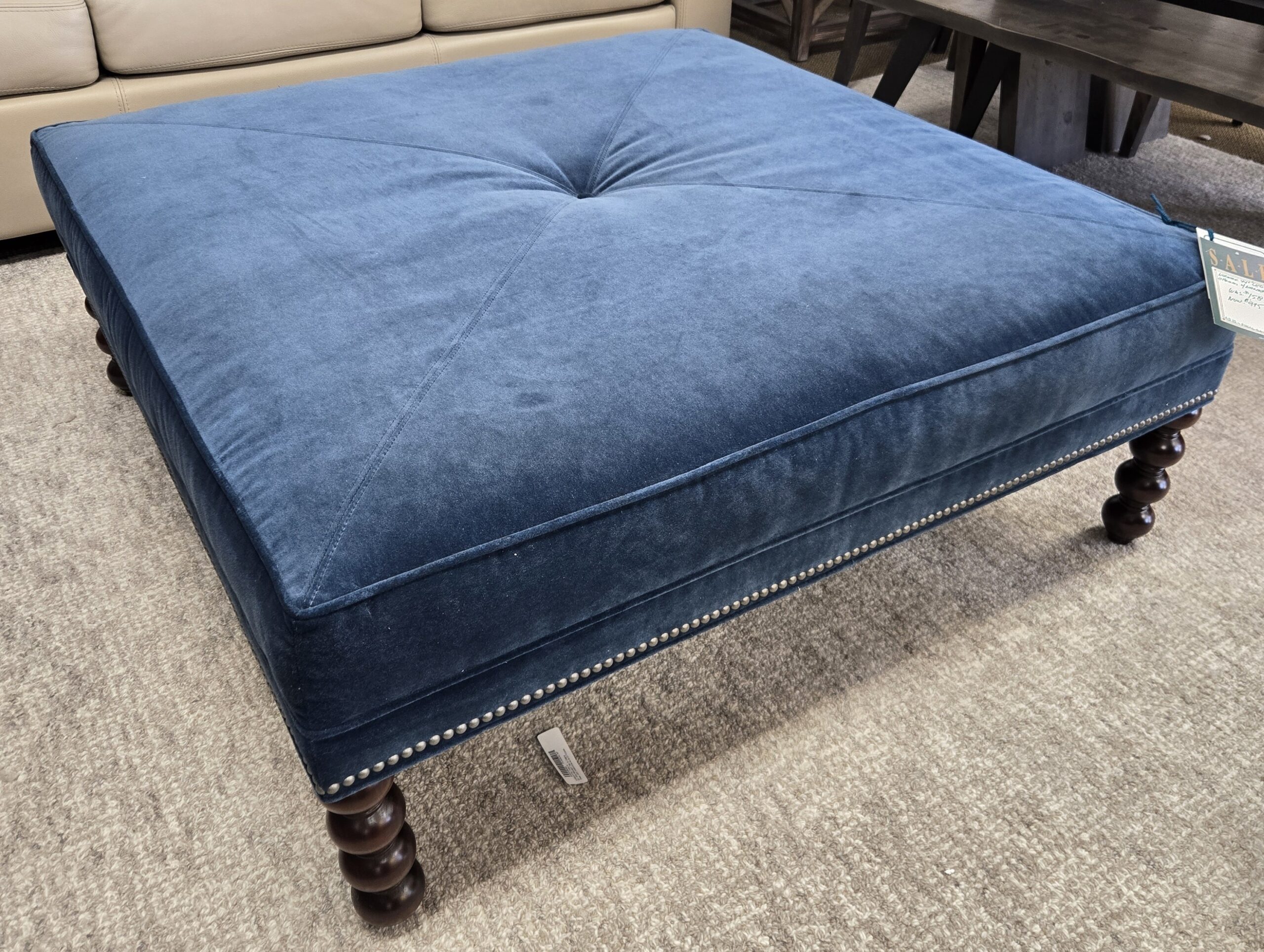 a blue ottoman sitting on top of a carpeted floor