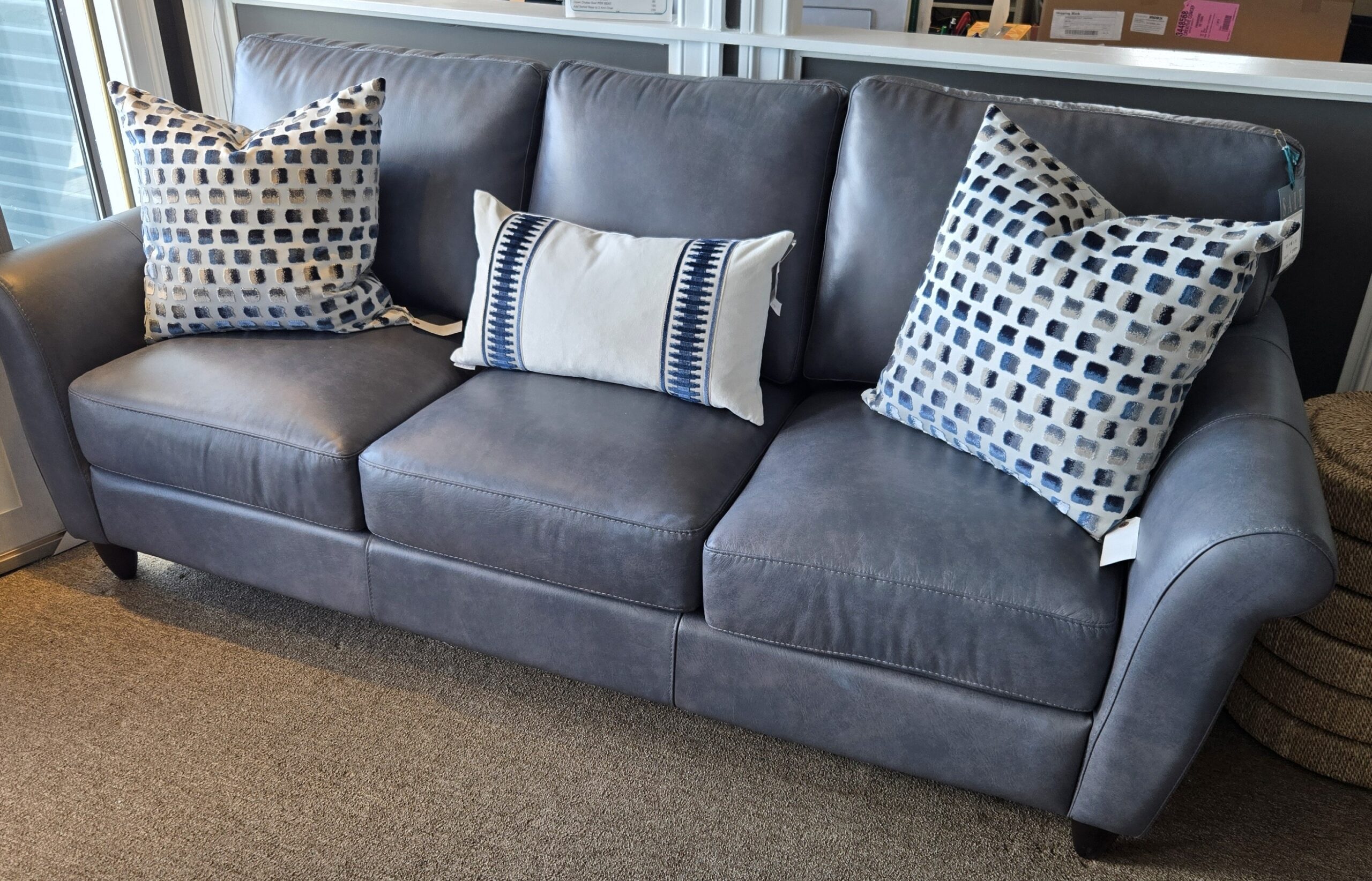 a gray couch with blue and white pillows