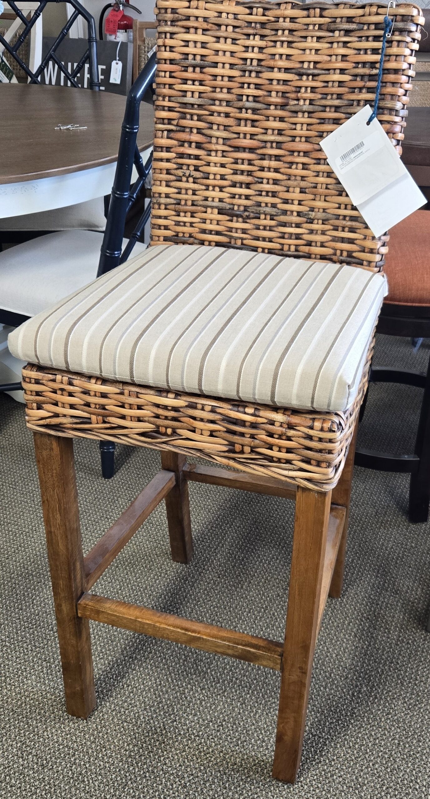 a wicker chair with a striped seat cushion