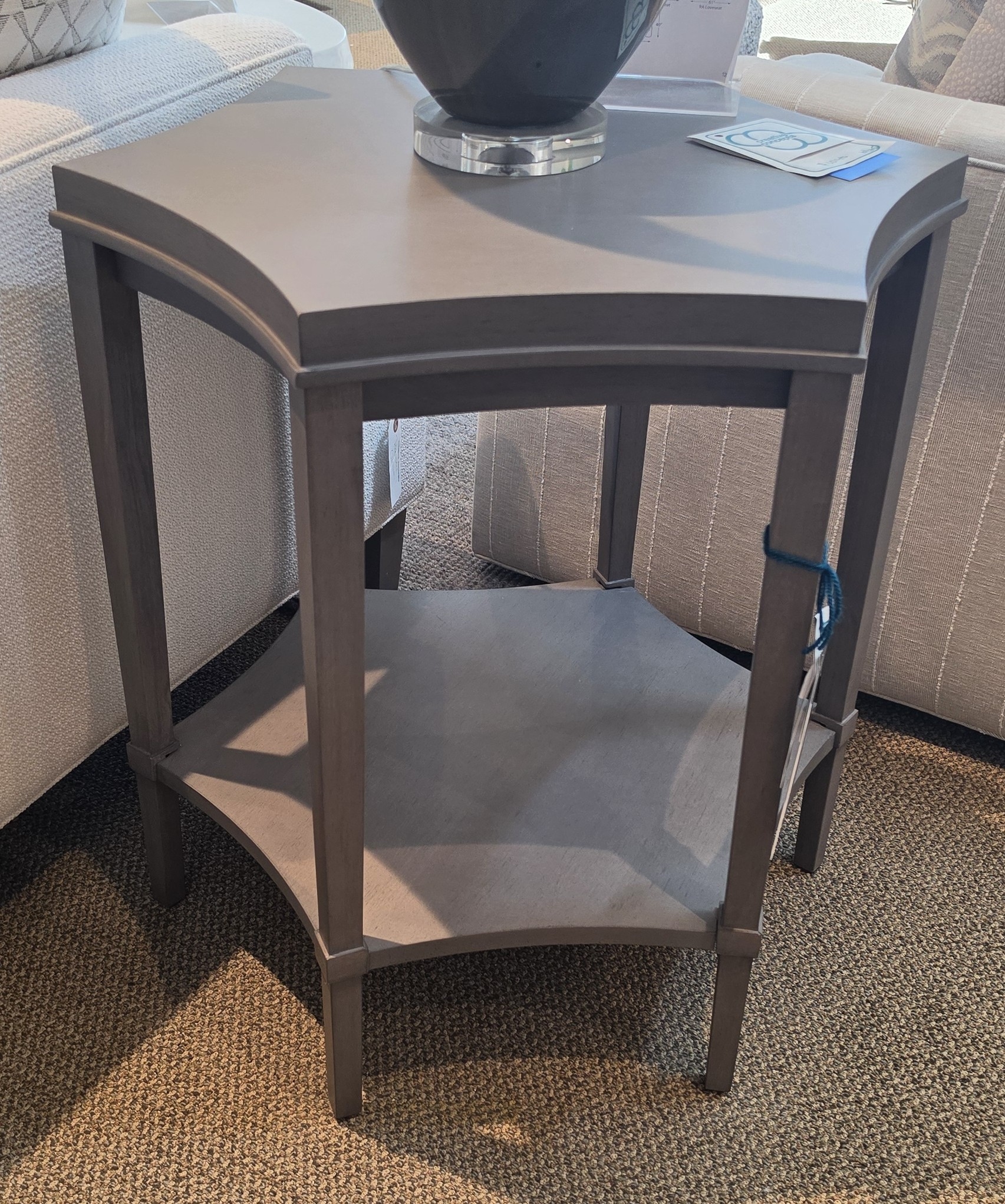 a corner table with a vase on top of it