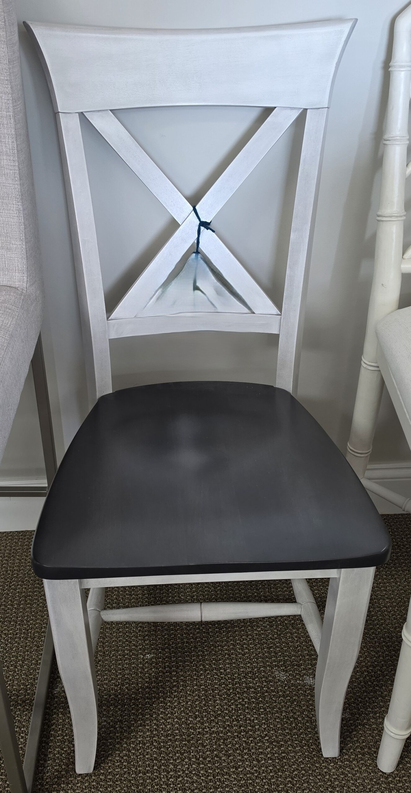 a white chair with a black seat next to a white chair