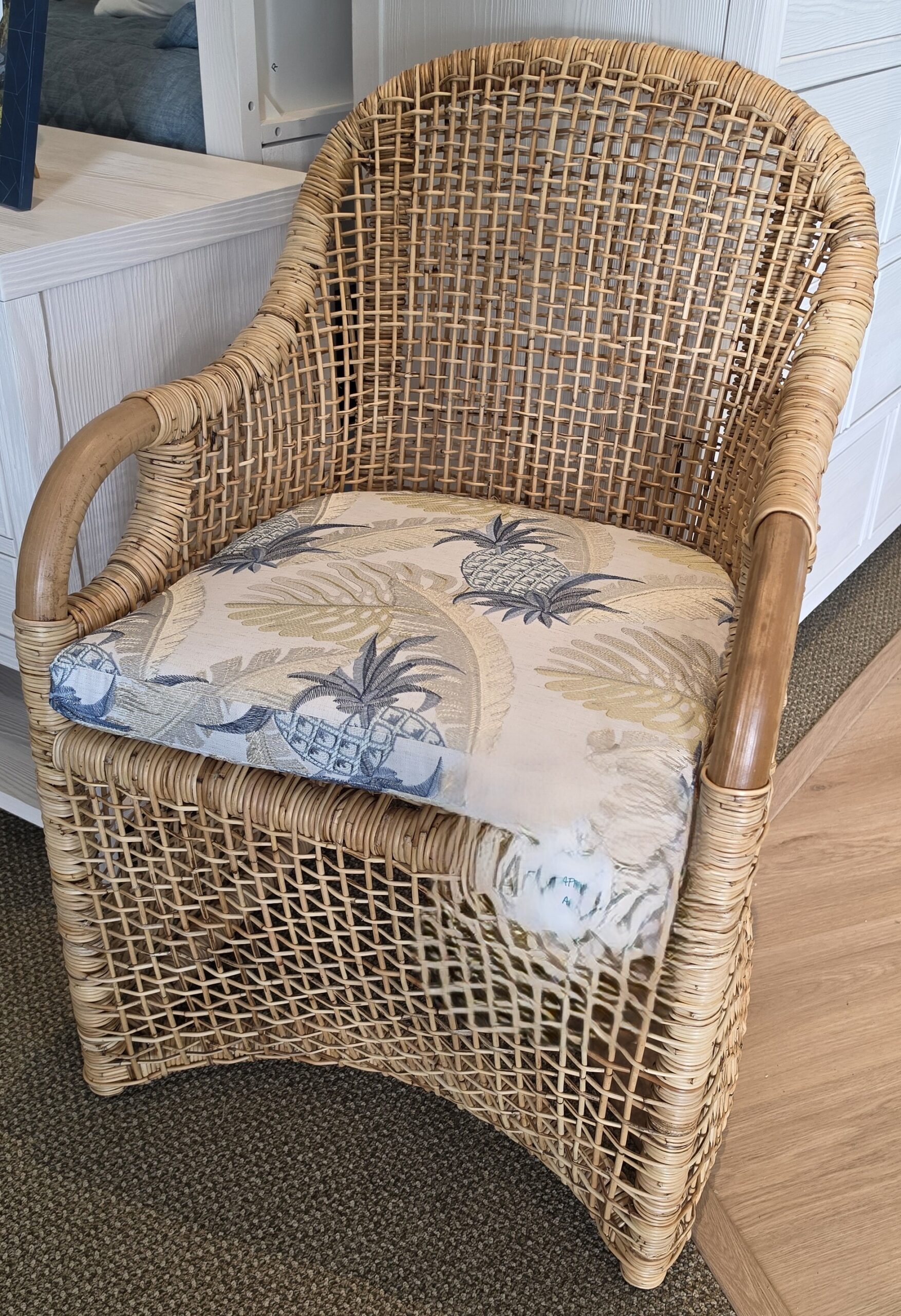 a wicker chair sitting in a living room next to a window