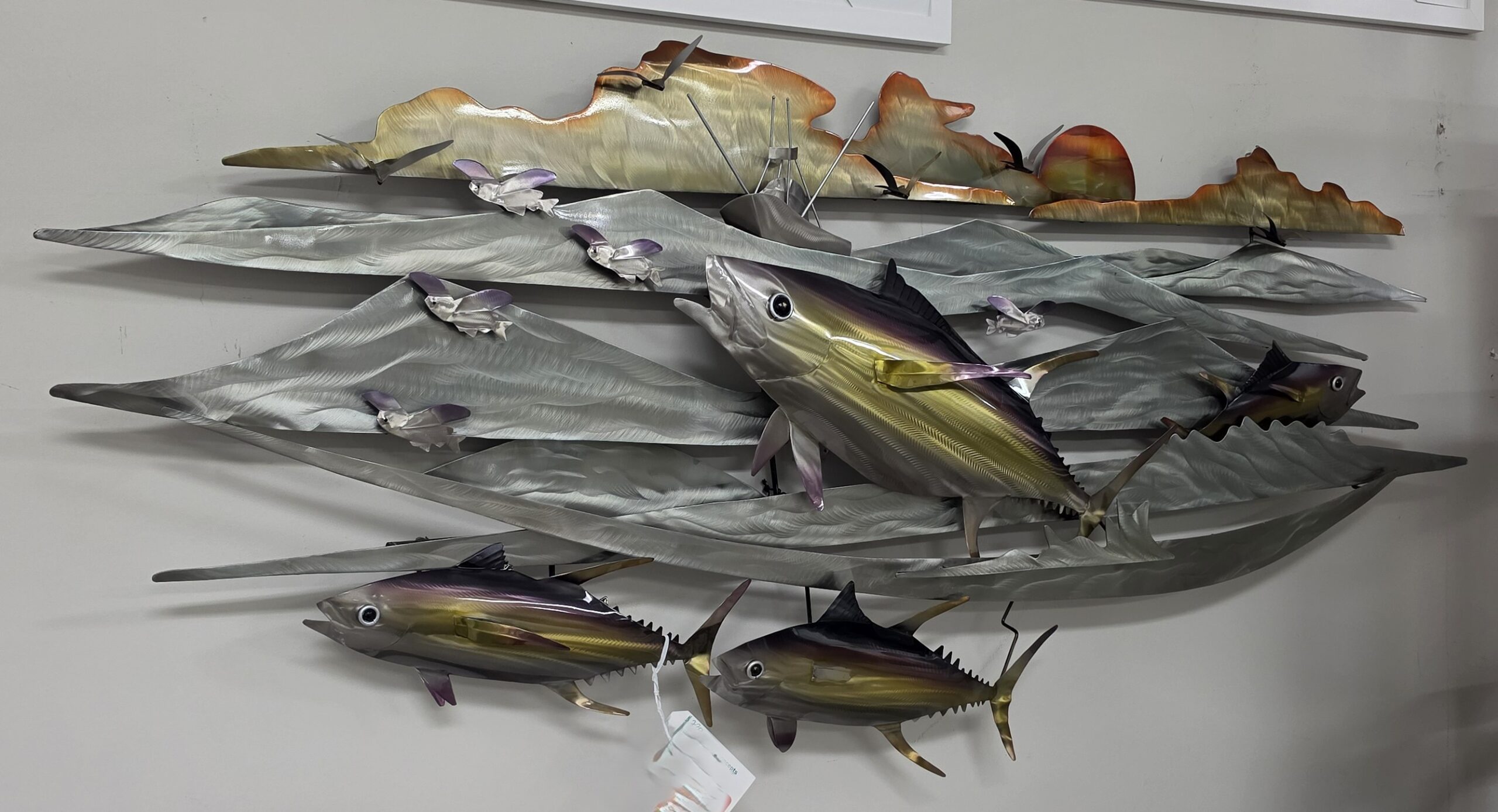 a group of metal fish hanging on a wall