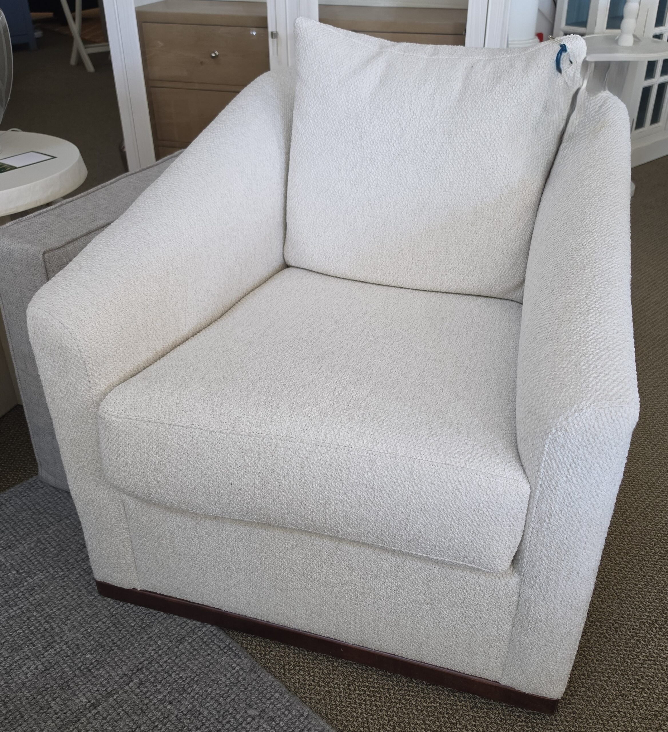 a white chair sitting in a living room next to a window