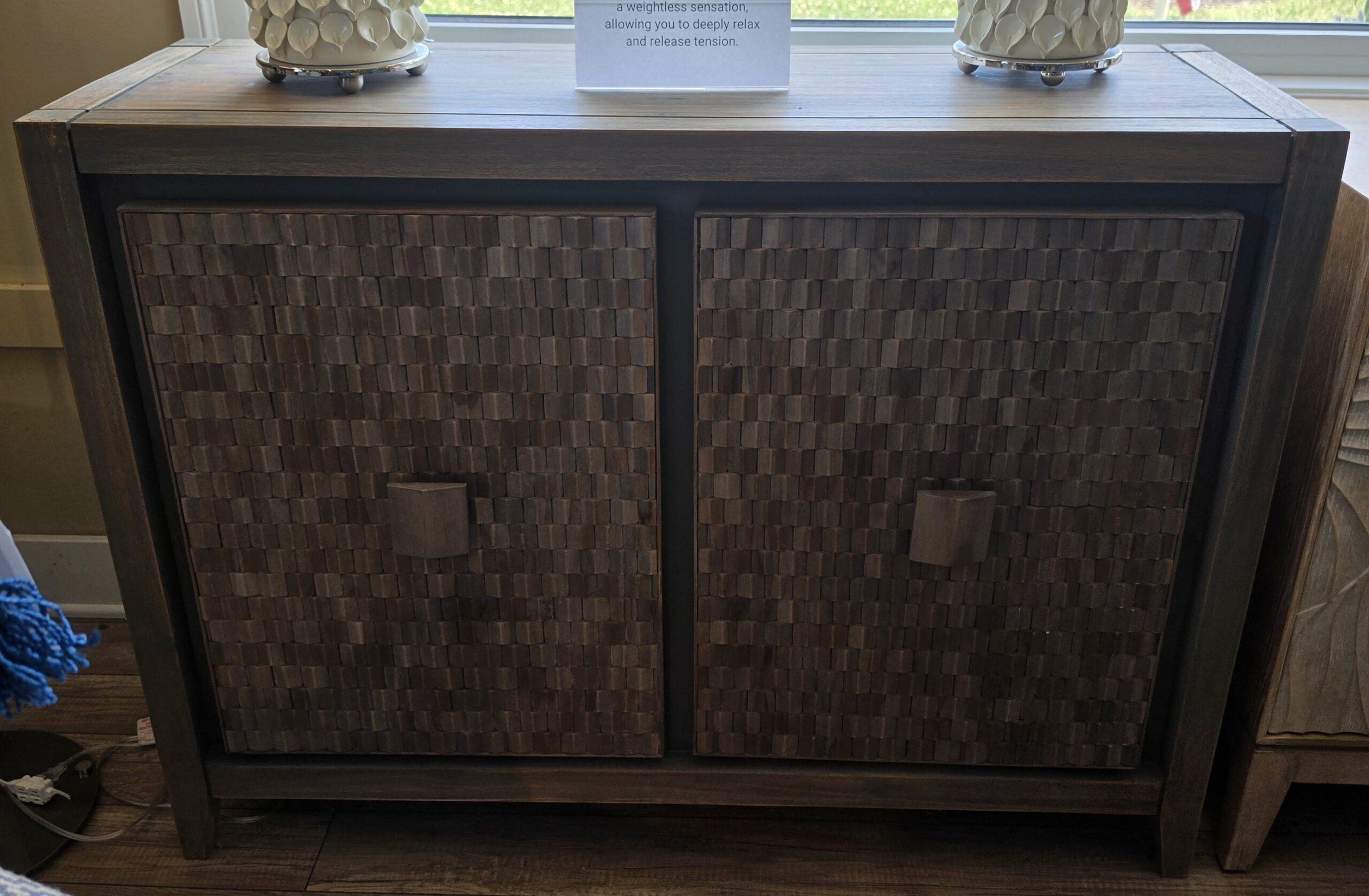 a wooden cabinet with two vases on top of it