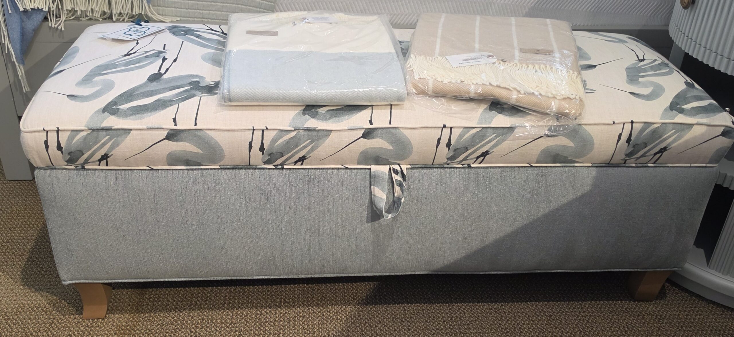 a bed with a blue and white blanket on top of it