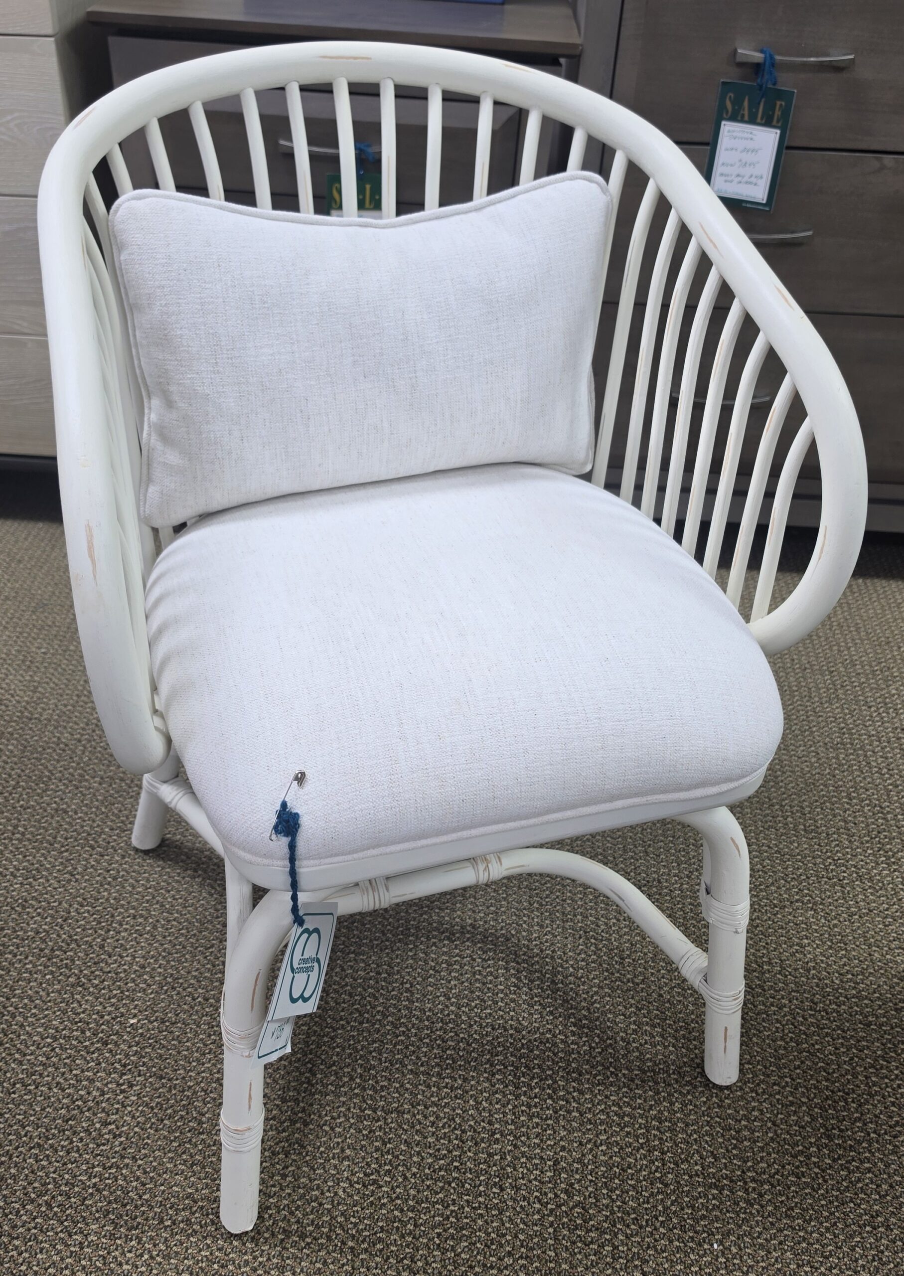 a white wicker chair with a white cushion