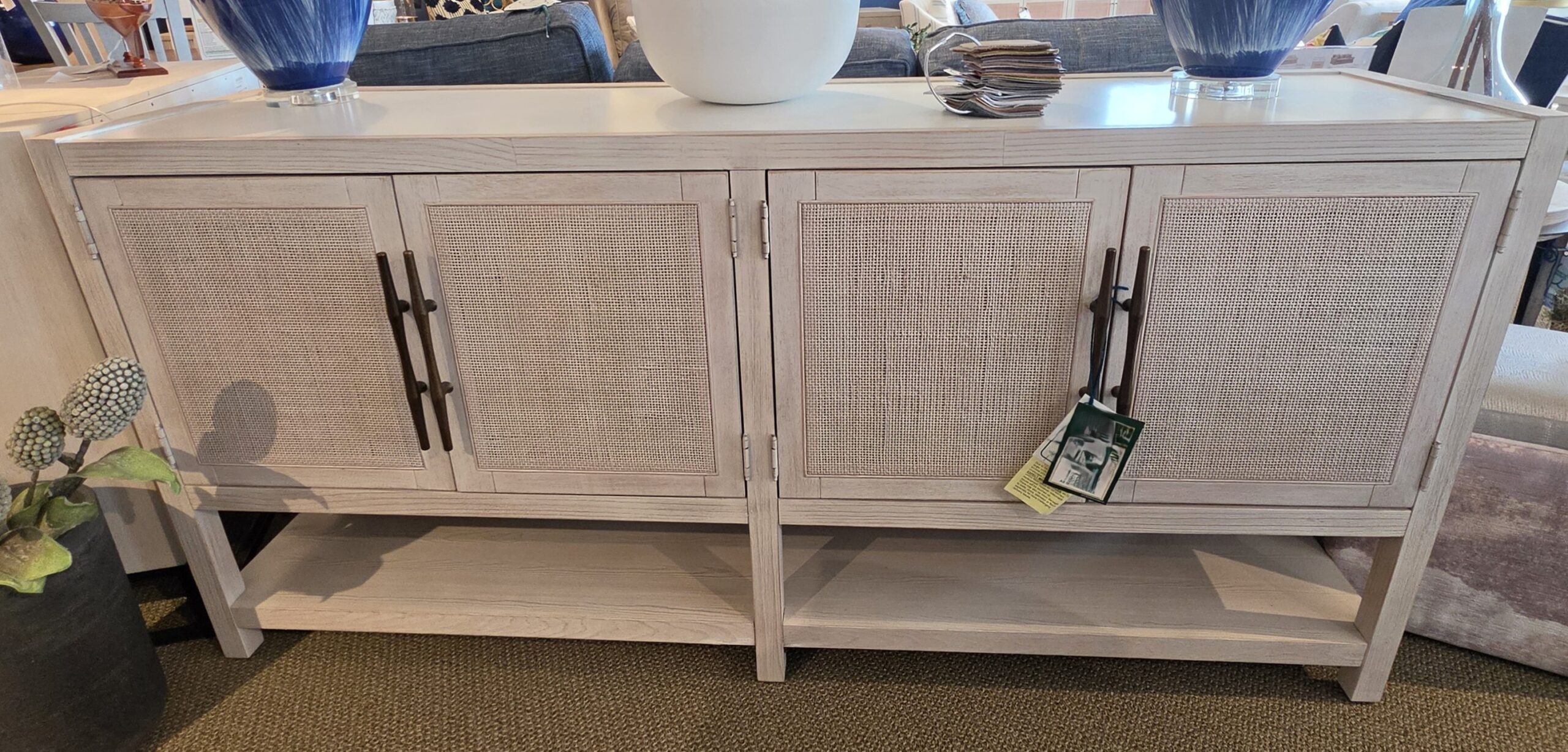 a white cabinet with blue vases on top of it