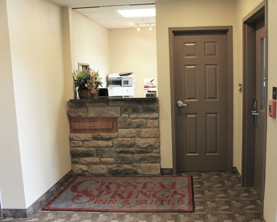 a hallway with a door and a rug on the floor