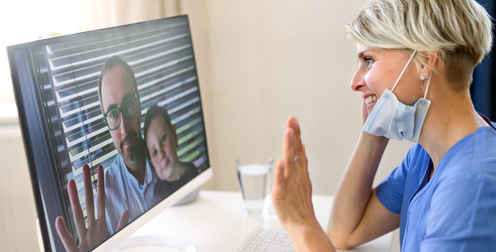 Doctor meets virtually with man and child