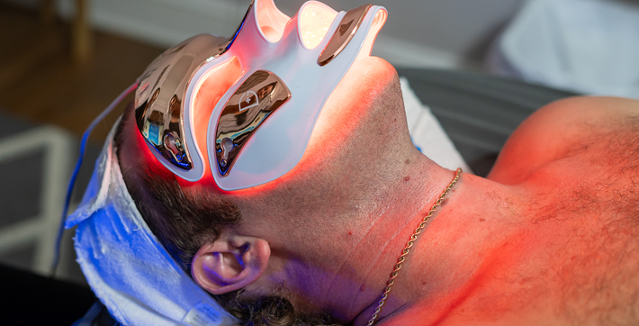 Man using red light therapy mask at Zen Spa