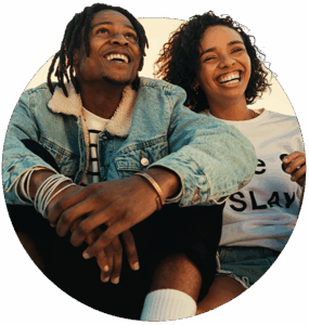 Two young people sitting side by side and smiling for Youth Empowered Society YES Case Study by D3