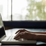 person sitting at a laptop typing