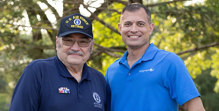 An older man and a man from Visiting Angels standing beside each other