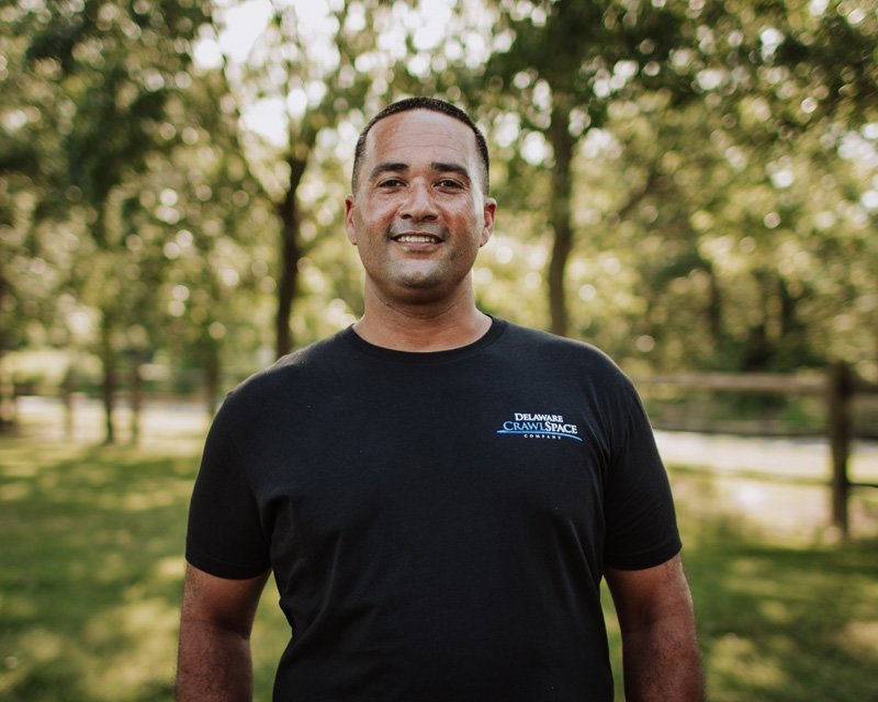 a man standing in a park with trees in the background