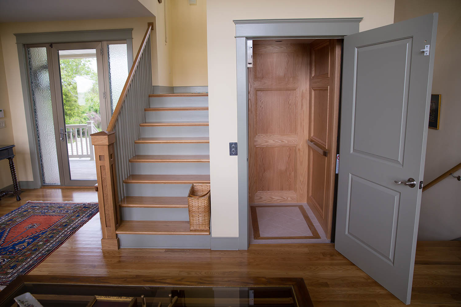 a living room with a stair case next to a door