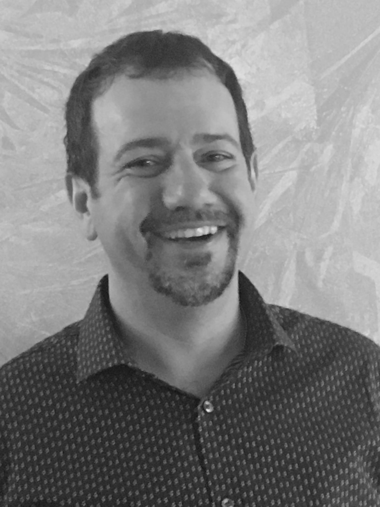 a black and white photo of a man smiling