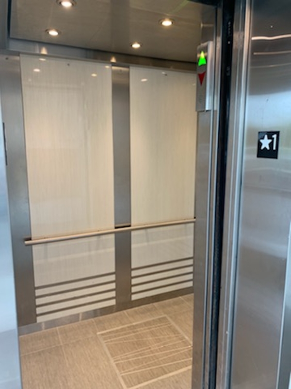 a stainless steel elevator with a sliding door