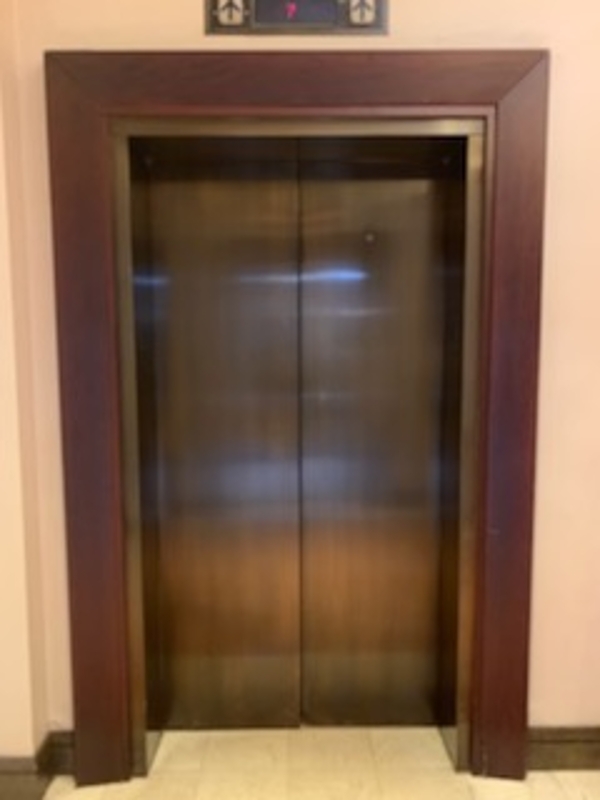an elevator in a building with a clock on the wall