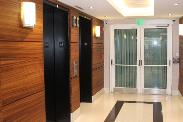 a long hallway with wooden doors and a black and white checkered floor