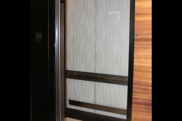 a tall cabinet with a sliding door in a room