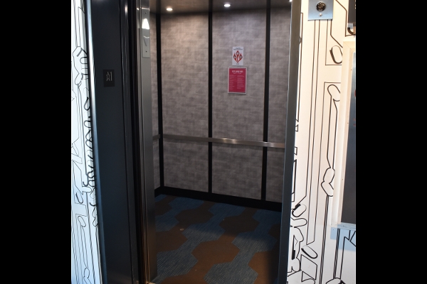 an elevator with graffiti on the walls