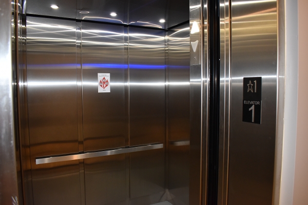 a stainless steel elevator with a toilet paper dispenser