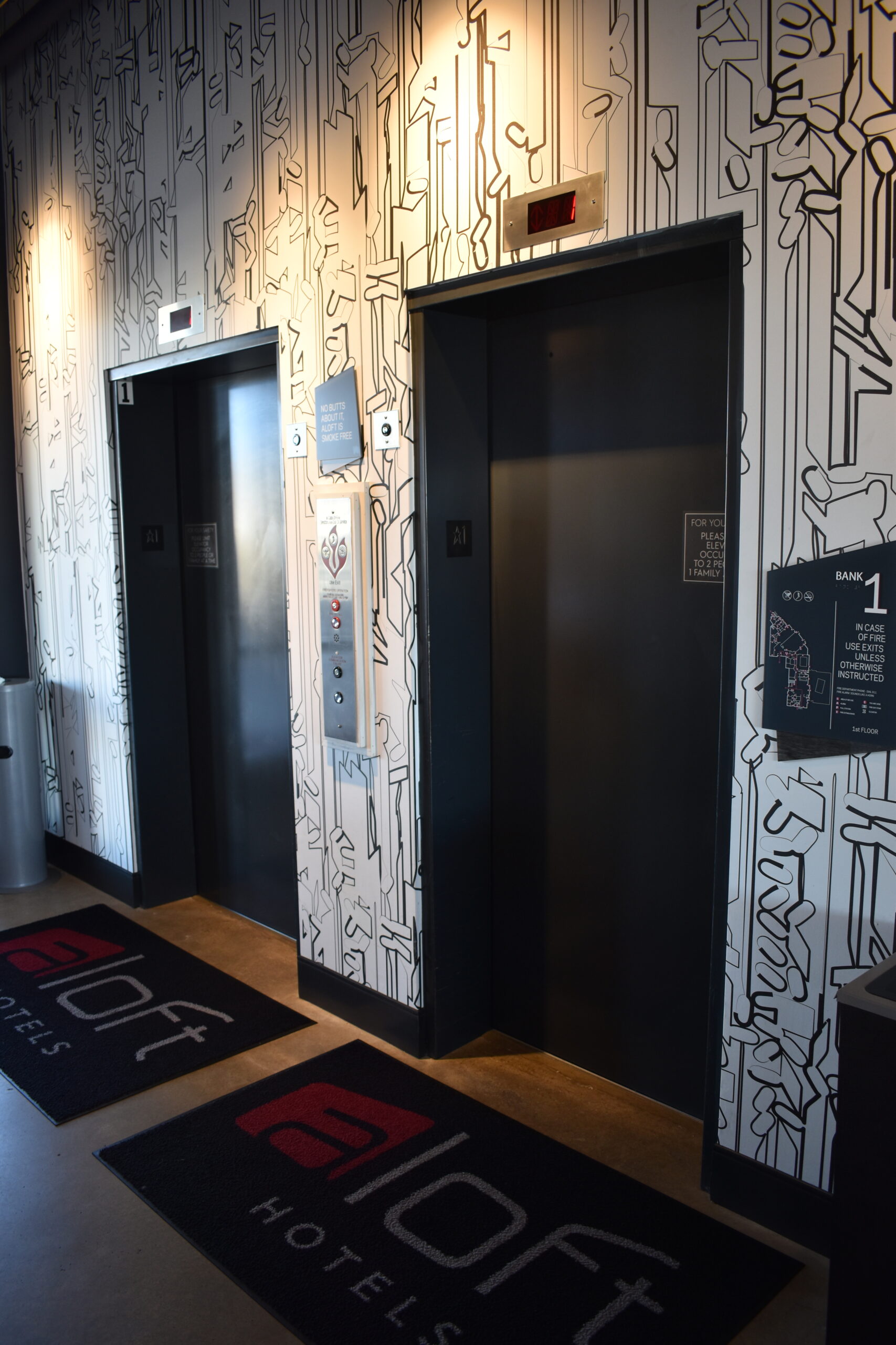 a bathroom with a black and white wall and a red and black rug