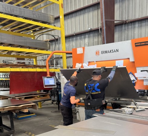 two men working on a machine in a factory