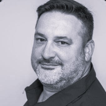 a black and white photo of a man smiling