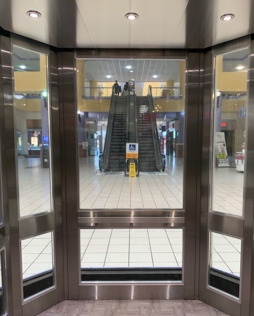 an empty lobby with two doors and a tiled floor