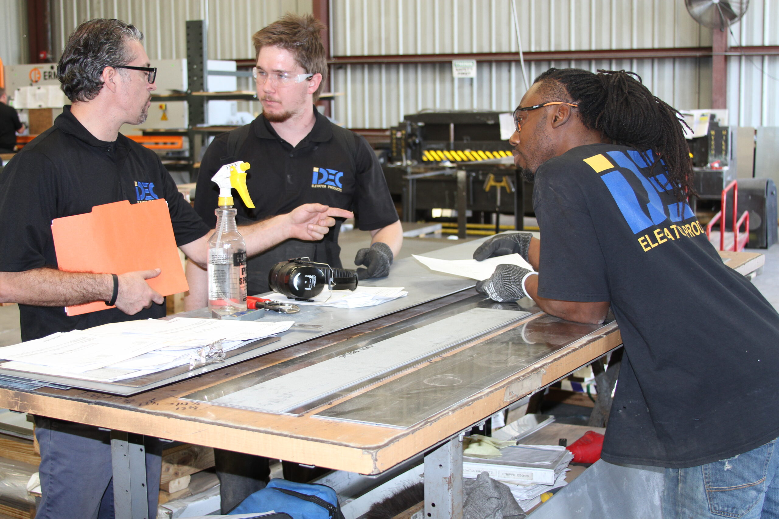 a group of men standing around a wooden table