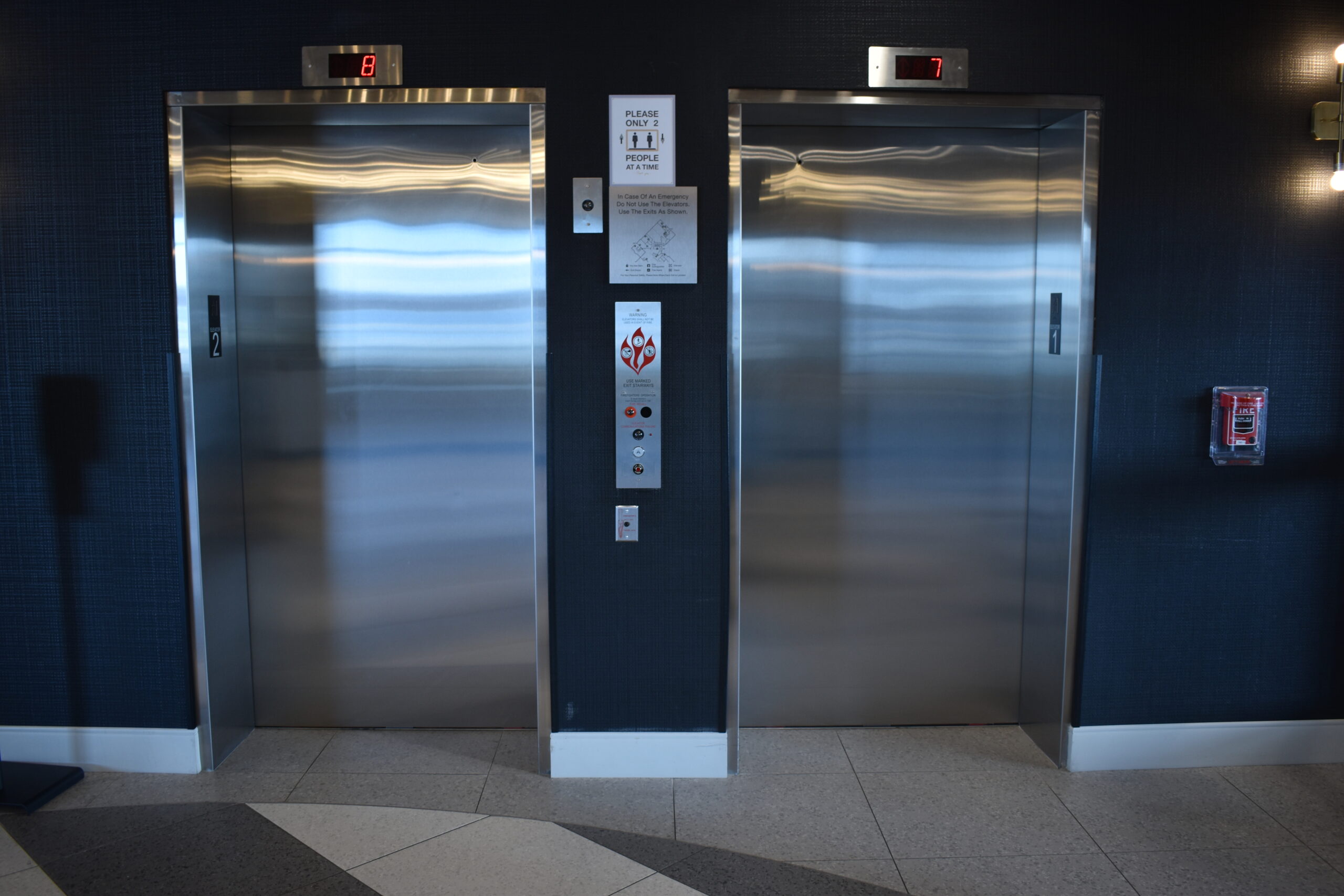 a couple of stainless steel elevators in a building
