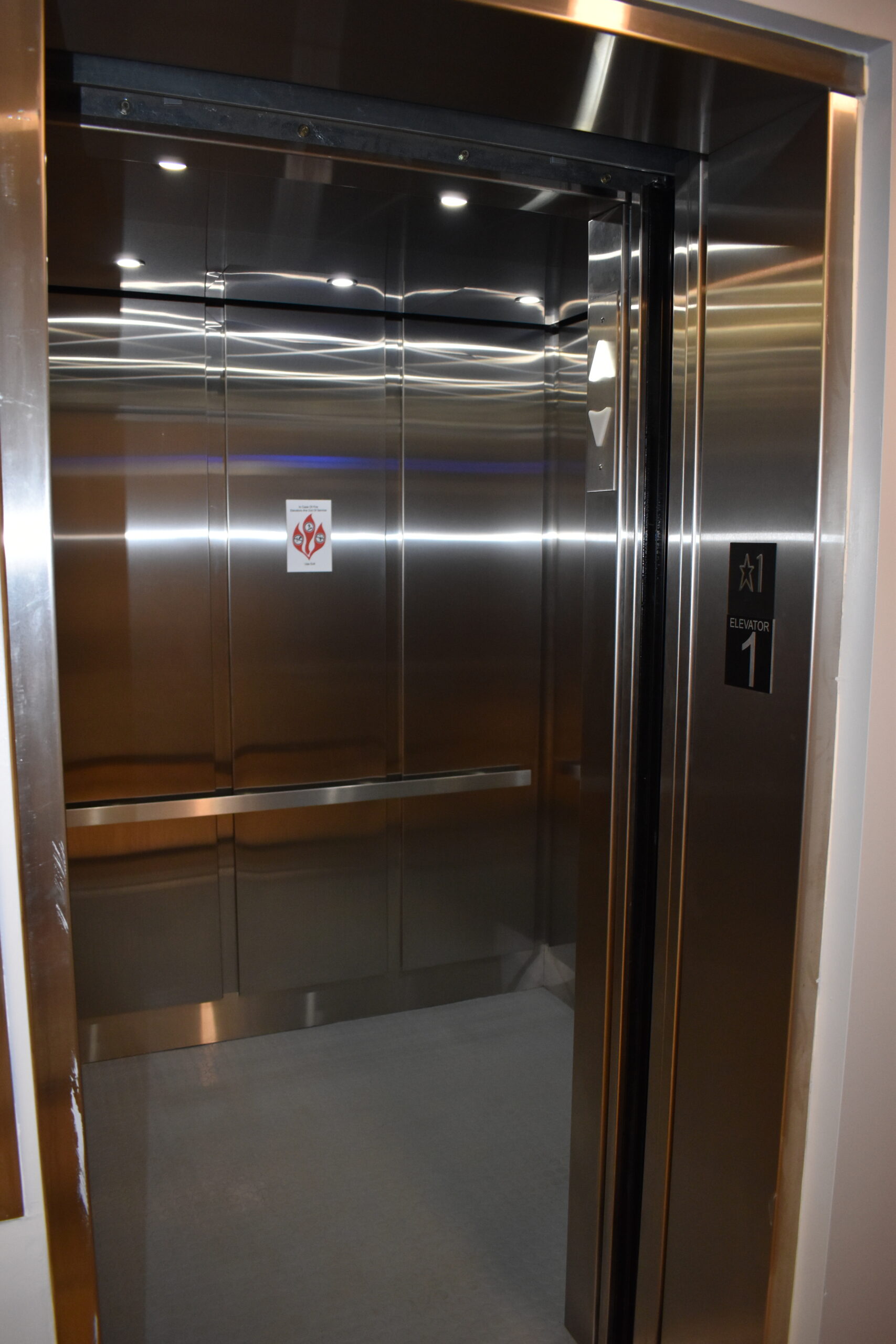 a stainless steel elevator with a sign on the door