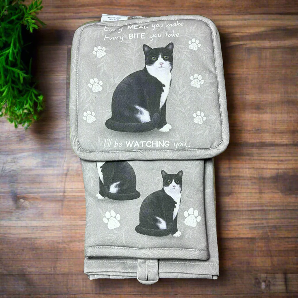 a black and white cat sitting on top of a blanket