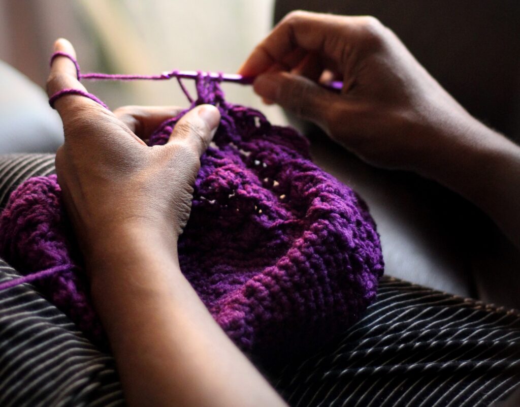 Picture of hands knitting with yarn.