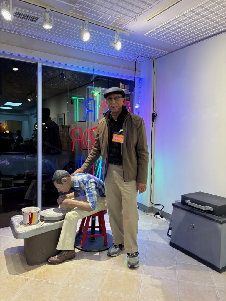 Ernie Satchell poses with “Labor of Love,” on display at the Dorchester Center for the Arts through February.