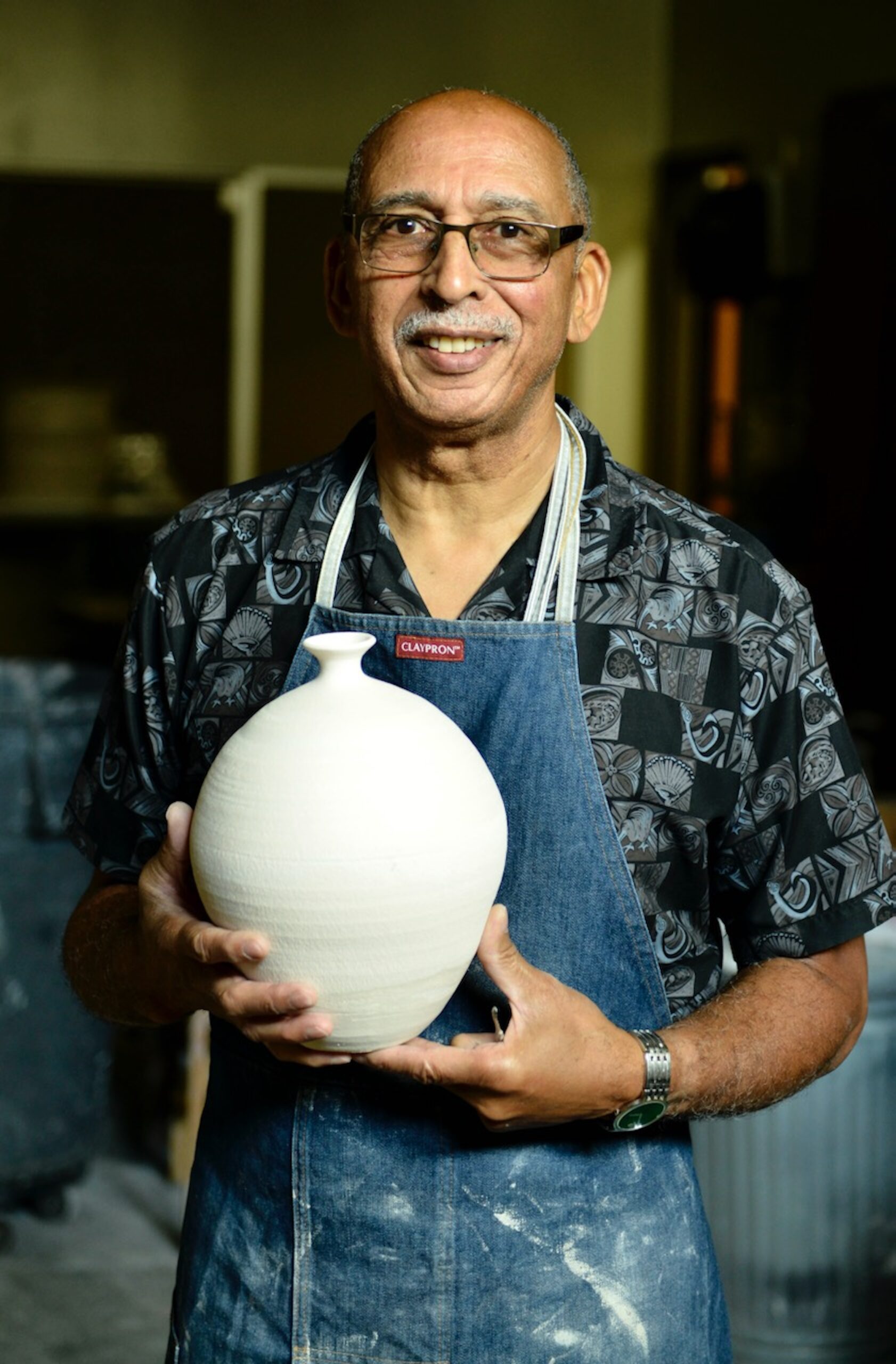An artist holding his clay project.